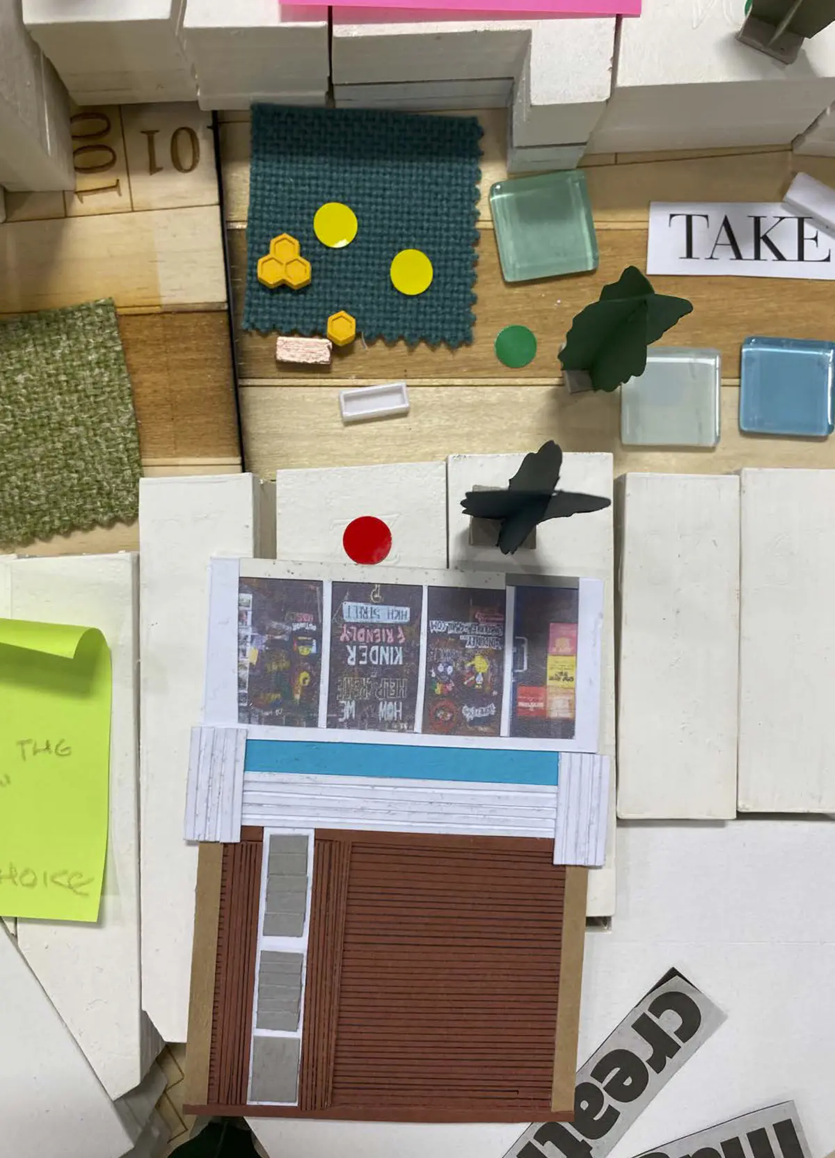 Looking to be the centrepiece of our exhibition, we proposed to create a site model of Dudley Highstreet at 1:200 scale with buildings modelled in a simple form. Local residents and visitors to the exhibition are then invited to decorate a chosen building to how they would envision it sat within the context of a greener Highstreet. We want to tie in our themes of biodiversity and materials by proposing that buildings can, and do, have the potential to be a lot healthier, sustainable, and interactive on the street. This site model also helps gain vital public opinions on the Highstreet and prompts discussion of areas most in need of attention.

To ensure that the model is utilising the MDF to the most efficient standard possible. First, the centres of the massing blocks have been hollowed out. This allows a reduction in materials used as other buildings can be cut in the centres of the model. Then the top is finished with a solid piece.
The waste material is placed into the recycling rack where other students can reuse it; otherwise, if the material left cannot be used for another project, it is recycled correctly by the university.

The model spanned just over 3.4m long and over 50cm wide. With the majority being cut from scrap woods that would fit the jigsaw of the shape, we were able to drastically cut down on waste. We also got some small benches and bee hives printed from recycled plastics, and used dried flowers as trees to represent the green spaces. Ultimately, the model seemed like a huge success, and really helped portray our ideas about Dudley High Street to those who came by. Everyone from Dudley who saw the model knew that it was the High Street, and interacted well with it. The size did make it difficult to move, especially to carry to the site, but it sat nicely in the centre of the the room and really drew people in to interact with it.

The model brought people in from outside to play with, write on, interact with. It became a spectacle for the public to come in and see what was happening and offer their ideas about what could be done.

The event was a success. Many people from the public (those who heard about the event, and those who just happened across it on the day) came in to interact with the model, which sat as the centre piece in the room. Kids liked to play with the pieces while the adults talked about things that could come from actions to help the High Street, not just leave it as is.

SOME OF THE KEY IDEAS WERE:
- The Shops need to be inviting for everyone. It’s no good having these places to go if people would rather take a bus to the next town.
- Just putting up boards across the windows is awful. Paint, Posters, Graffiti: Anything that actually makes the High Street look still alive is better than just wooden boards.
- More Green is needed. While it is obvious that there is a lack of Trees, many people wanted to push for these small bushes or planting spaces that could easily be implemented across the street.
- Spaces for public events or for people to at least gather at. While there is the Market and Fountain, it is not enough for the people of Dudley.
- Something needs to be done about the cars on the High Street. Some were Pro-Removal of all Cars, while some just wanted to limit when they could access the High Street.

Following the exhibition we created a series of drawings with our own interpretation of Sarah Wigglesworth ‘The Dining Table’ drawing. The drawings are a perfect representation of the our interactive model at the ERA Environmental Exhibition and Event. Showing the interaction the public had with the model, as well as the conversations that were held around the model. - Table 5.png